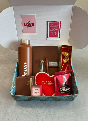 Gift box with a brown water bottle, wallet, and other items on a light gray surface.