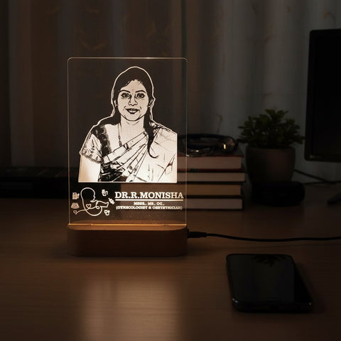 Lamp with engraved portrait and text on a desk