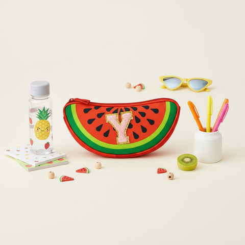 Watermelon-shaped pouch with letter 'Y' surrounded by stationery items on a light background
