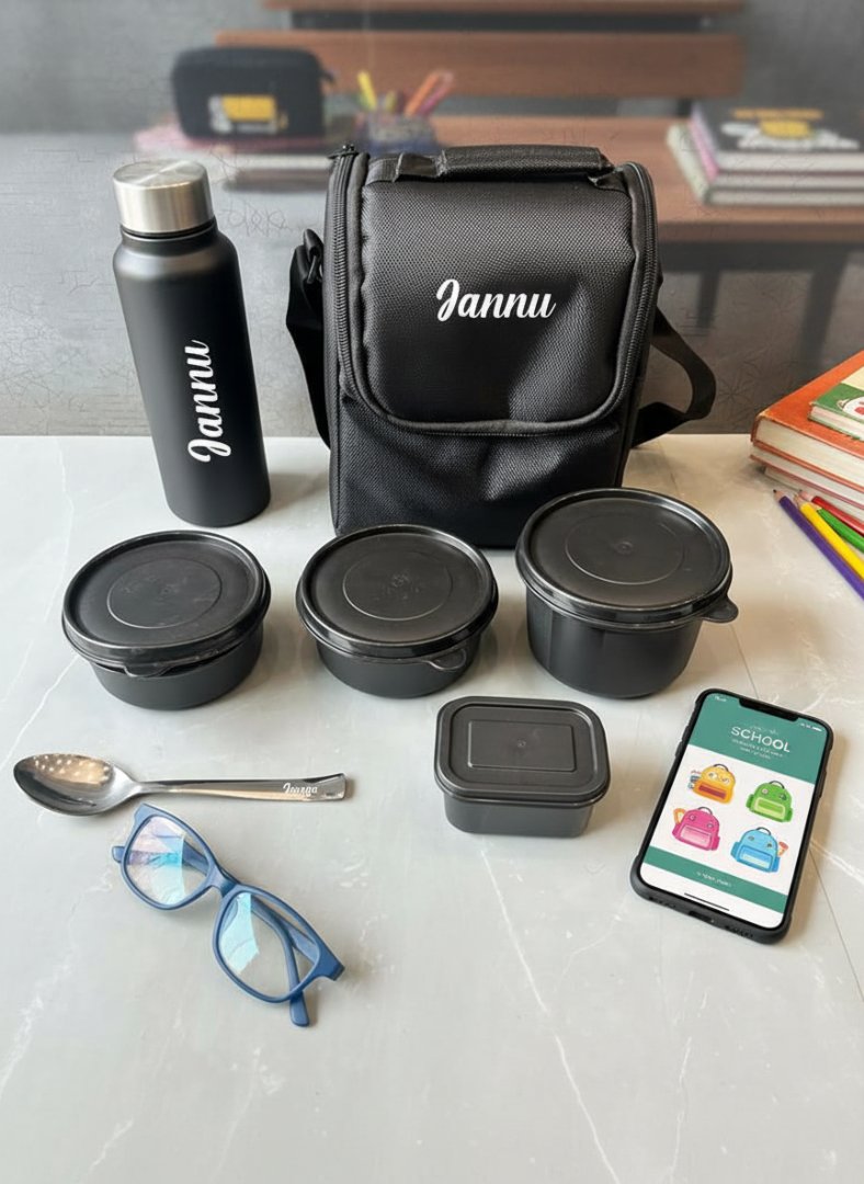 Black lunch bag, containers, bottle, and phone with app on a white surface.