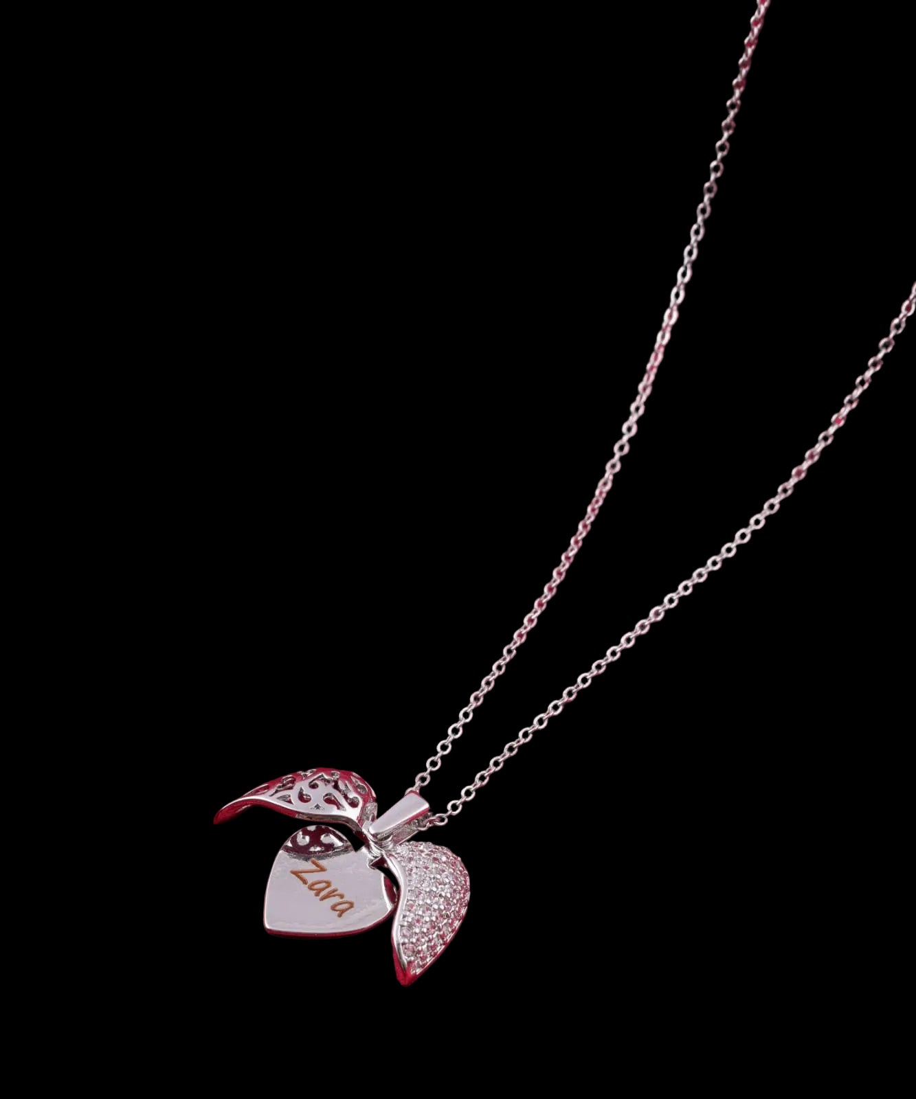 Silver necklace with a heart-shaped pendant on a red fabric background