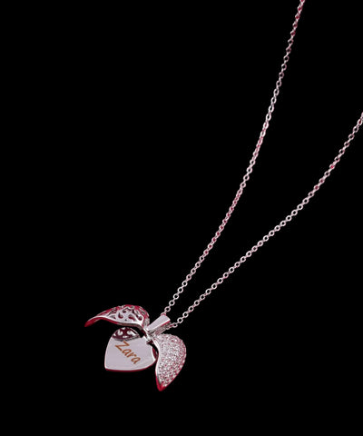 Silver necklace with a heart-shaped pendant on a red fabric background