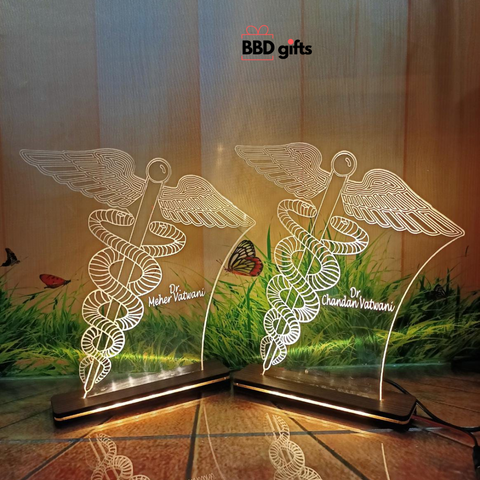 specially made for doctors, it is a table top with led, big doctor symbol is engraved,we can engrave any custom logo and we can engrave custom name. placed on floor adapter wire connection is visible light is on background grass is visible. 2 table tops placed 