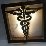 doctor logo with customized names wooden frame with warm light having wire connection to on light placed on floor