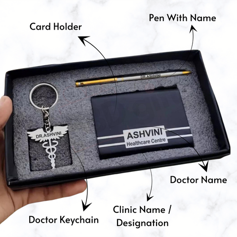 a man hold a opened balck box, where it contains personalized doctor symbol key chain, customized gold and grey color pen, black color premium customized wallet with name and designation