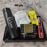 A gift set including a black thermos labeled custom name a pen with a medical symbol, a keychain with a stethoscope charm, a perpetual calendar with custom name inscribed, and a miniature doctor’s coat. The set is presented on a black tray with a marbel floor background.